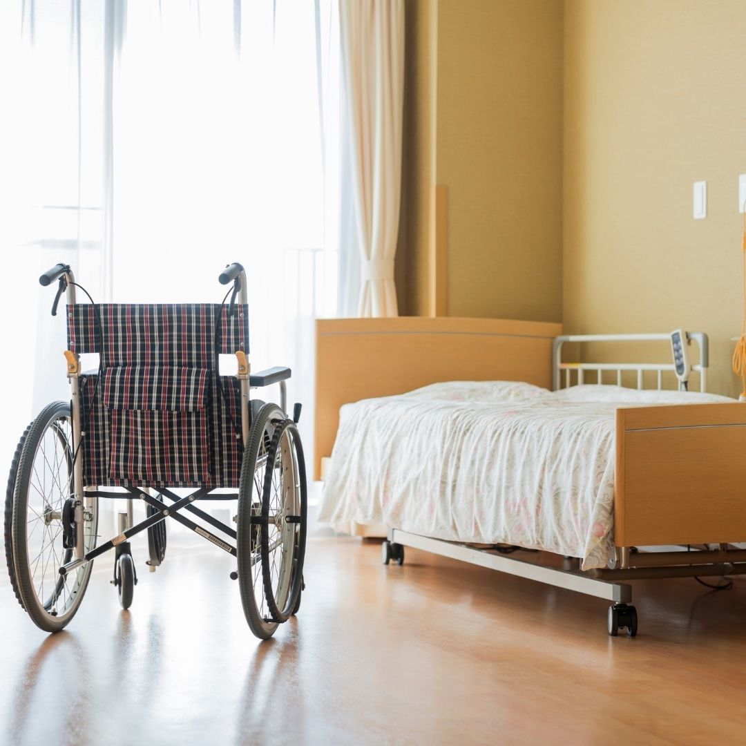 Empty wheelchair next to bed