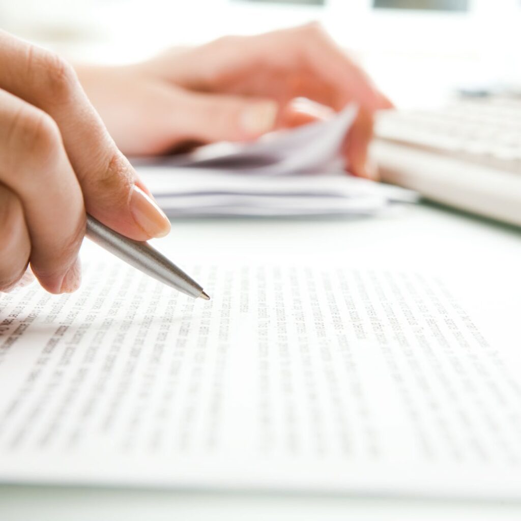 Closeup of hands holding a pen and paperwork