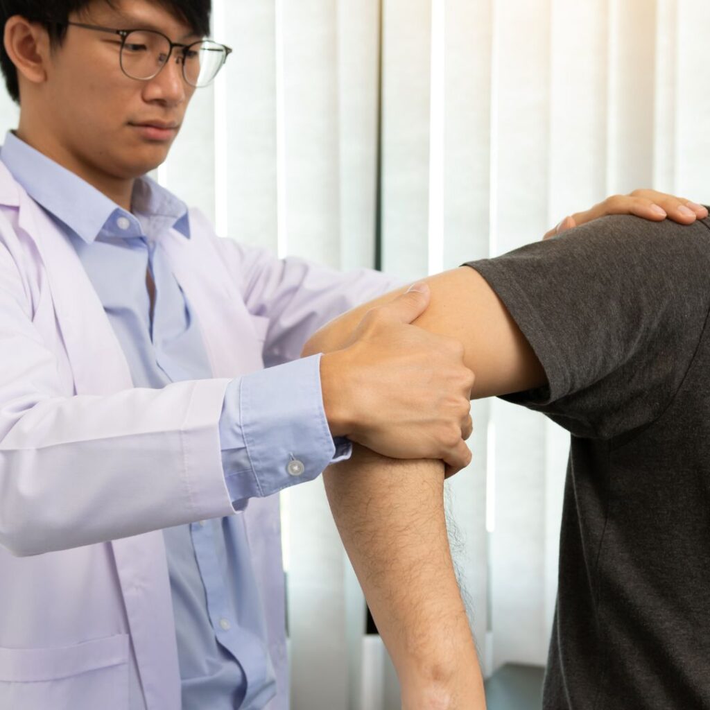 a physical therapist looking at an arm